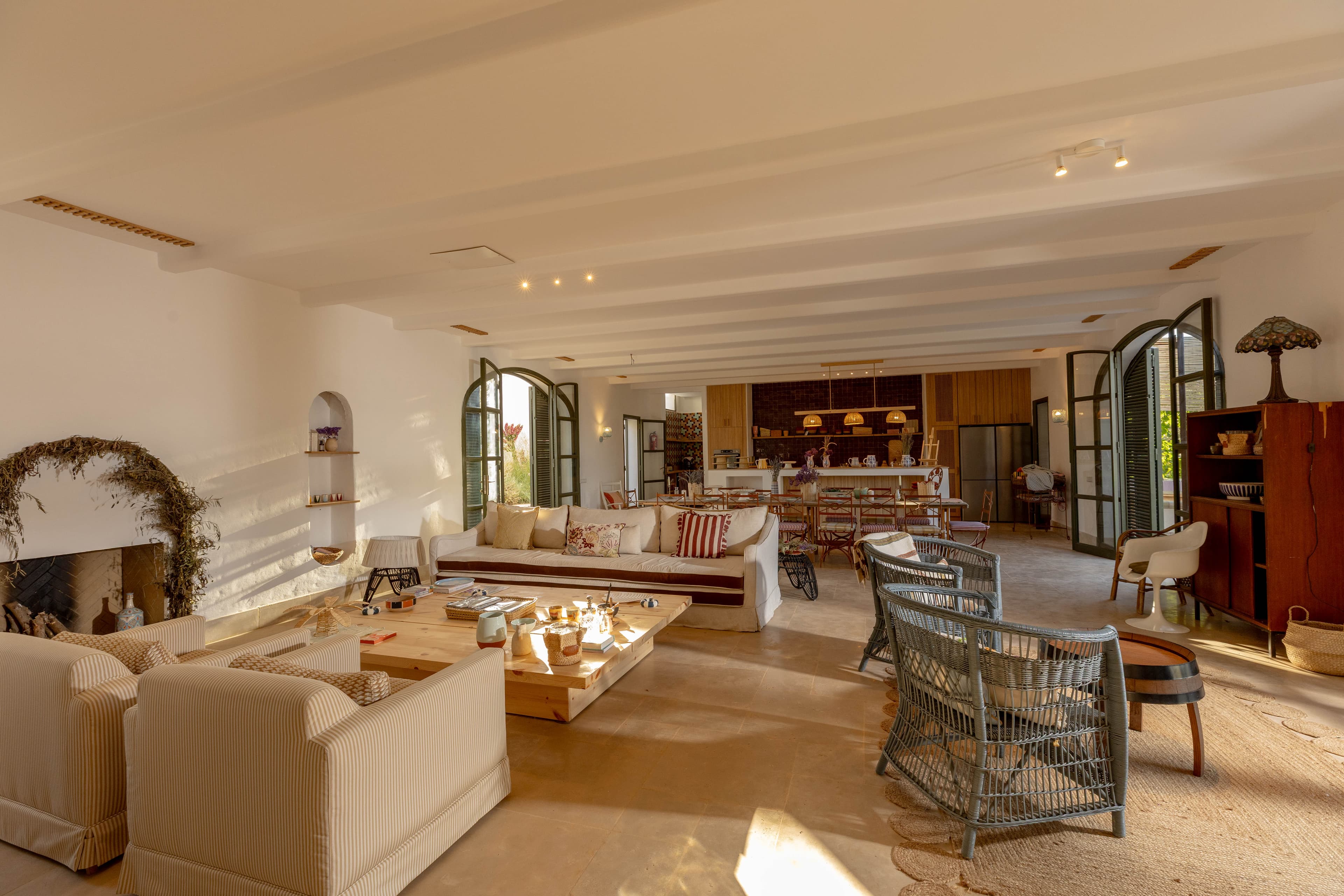 La cheminée de la Grande Maison, couronnée de feuillages séchés, et les canapés rayés
