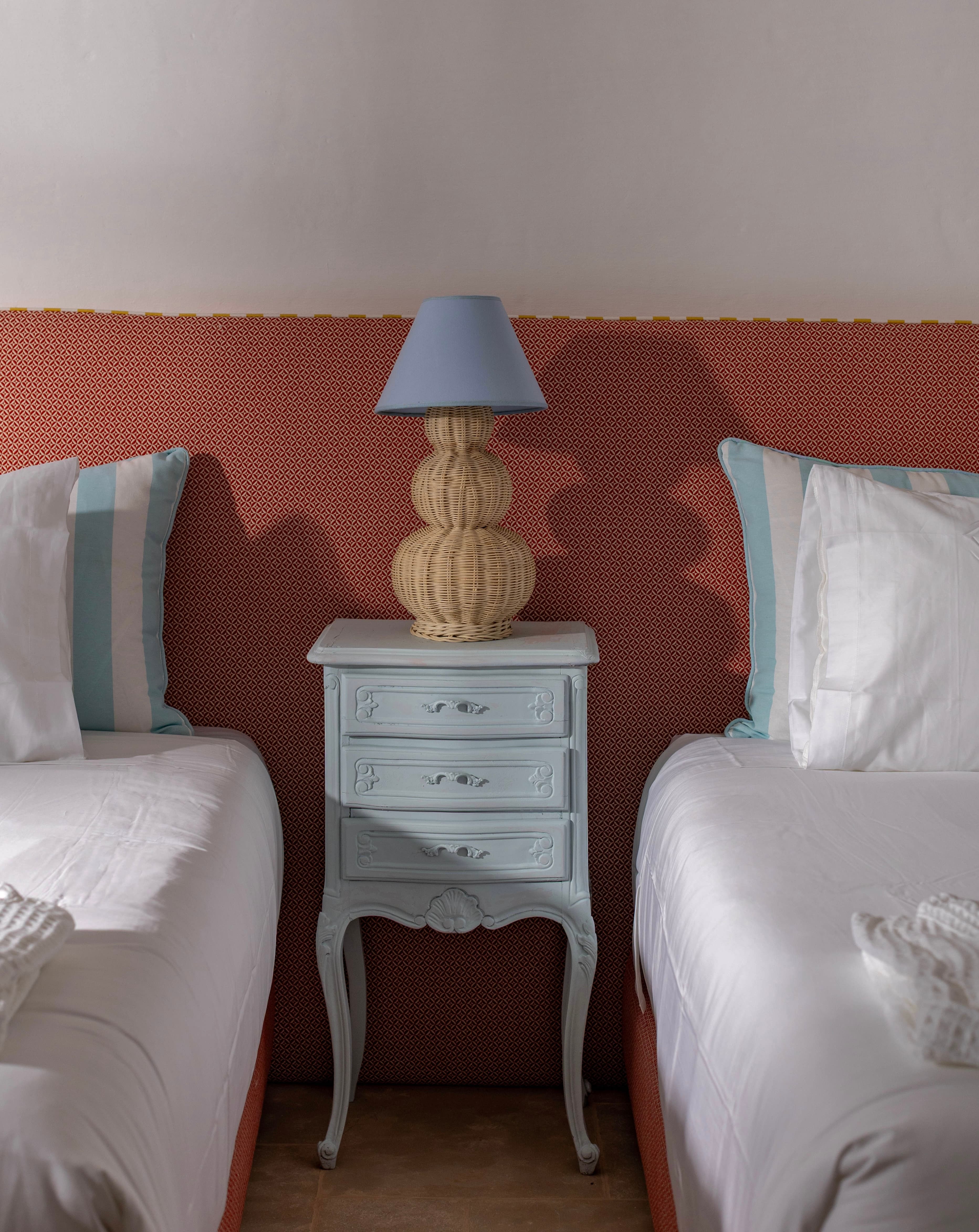 Chambre twin aux deux lits simples, tête de lit ondulée terracotta et coussins rayés bleu ciel