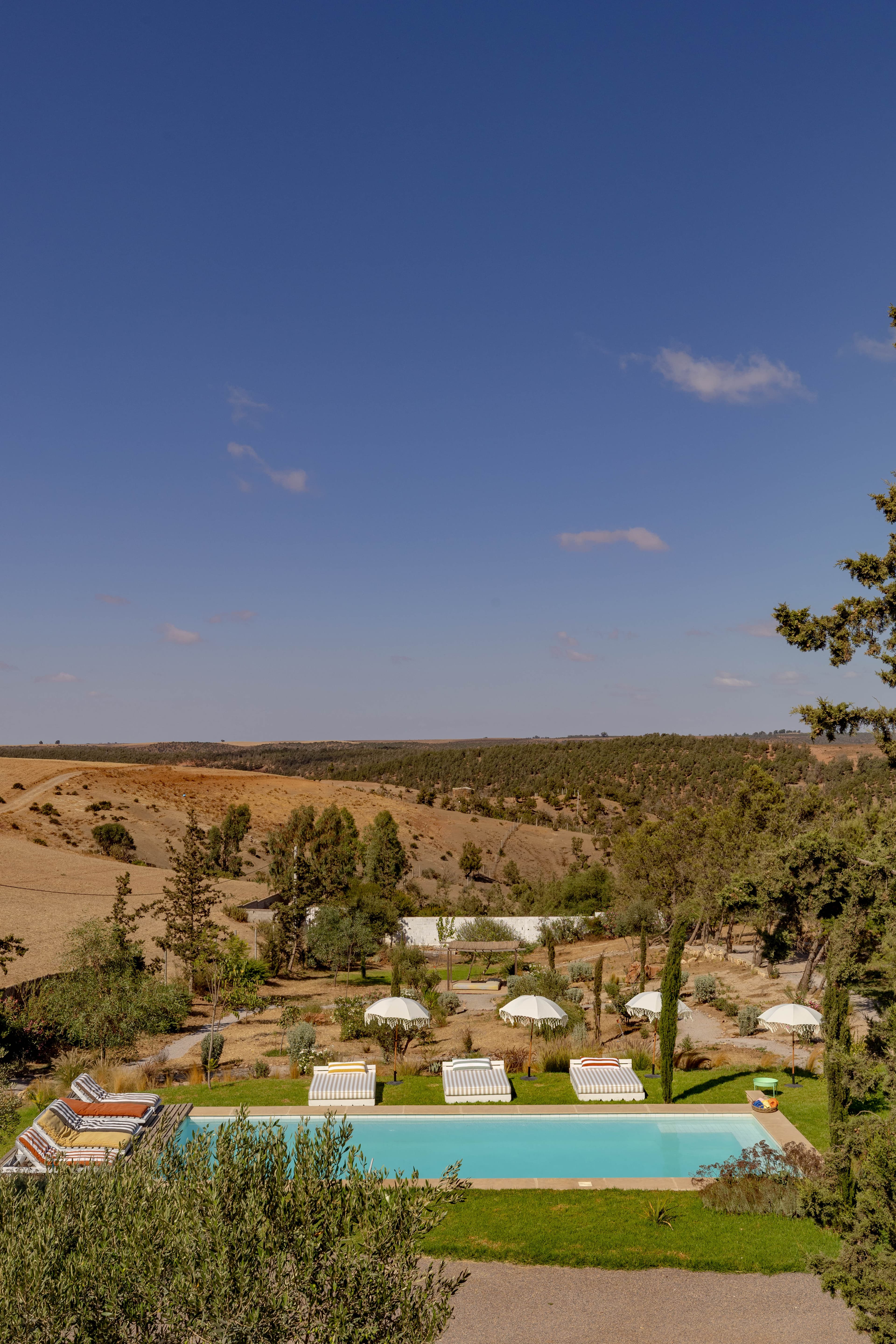 La vallée de Benslimane à perte de vue derrière la piscine et les jardins du domaine